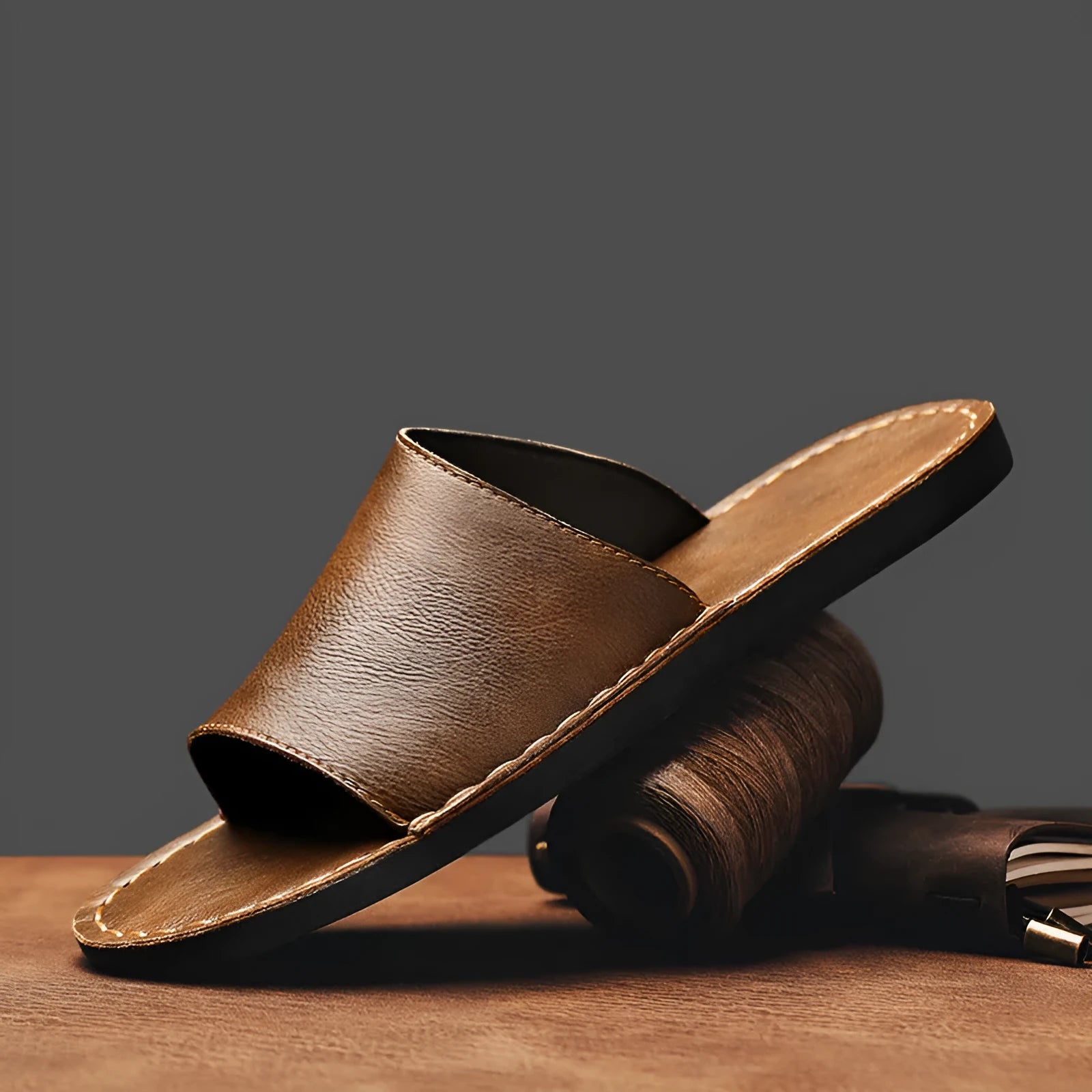 Brown leather men's sandals with a rubber sole on a neutral background