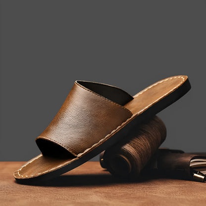 Brown leather men's sandals with a rubber sole on a neutral background