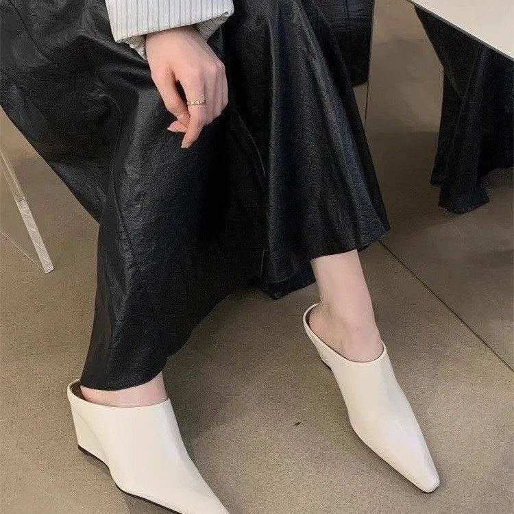 Women's black wind wedge closed toe half slippers showing PU upper and open back.