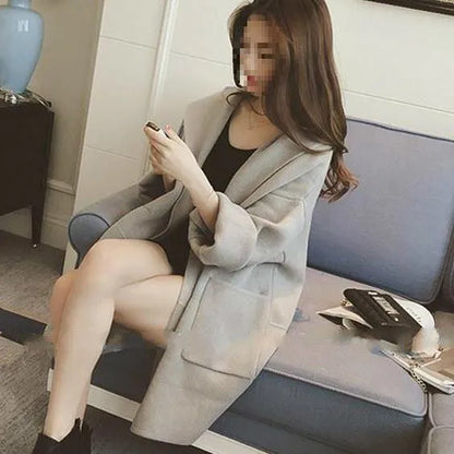 Plus size woman modelling a loose fit grey thin coat with lace detailing and long sleeves.