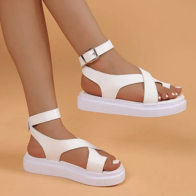 Women's white and black Roman-style lace buckle sandals with thick composite sole on a neutral background.