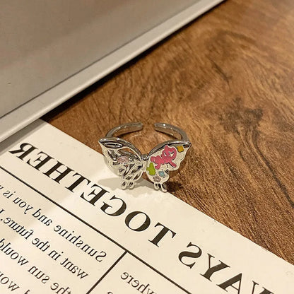 Copper butterfly women's ring with an open loop design on a plain background.