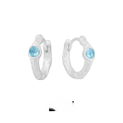 Geometric burnt silver sterling silver ear clip for women on a plain background.