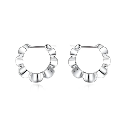 A pair of shiny silver geometric stud earrings with a round design on a plain background.