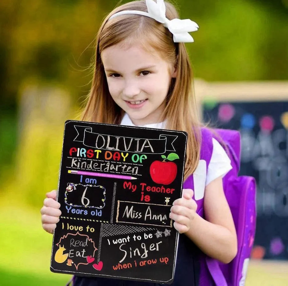 Wooden first day of school blackboard sign on a natural wood background.
