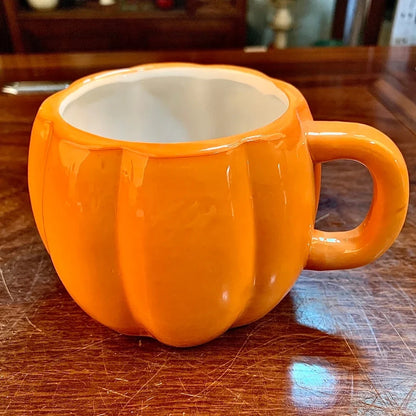 Ceramic Halloween pumpkin mug with cartoon face, 350ml capacity, 7.5cm diameter, includes matching spoon for seasonal drinks