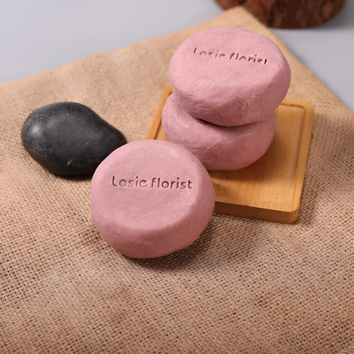 Pink round handmade rosewood grinding soap with roselle and tangerine peel ingredients