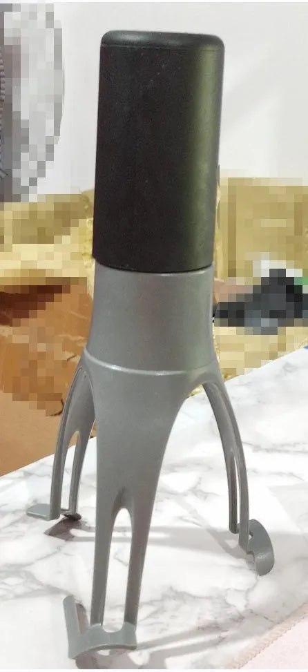 Green Uutensil Stirr automatic pot stirrer device standing next to a saucepan on a kitchen counter