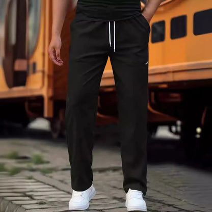 Men's light grey polyester trousers with an elasticated waistband laid flat