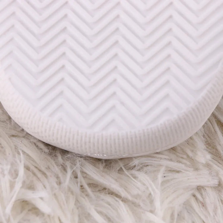 White fluffy cartoon-pattern slippers with a rubber sole and artificial wool lining.