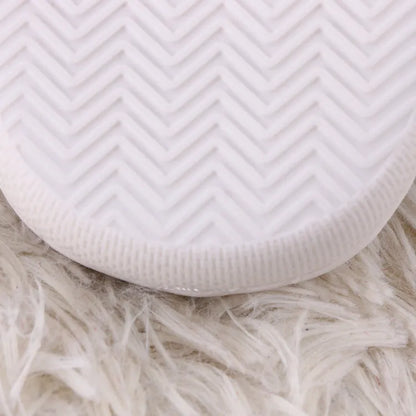 White fluffy cartoon-pattern slippers with a rubber sole and artificial wool lining.