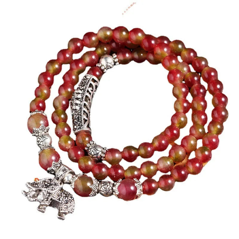 Handmade bracelet with green and pink watermelon crystal beads tied with Chinese knots.