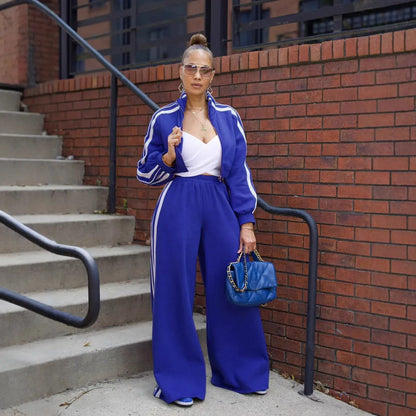 Woman wearing a grey striped zipper sweater and matching trousers from a casual two-piece set.