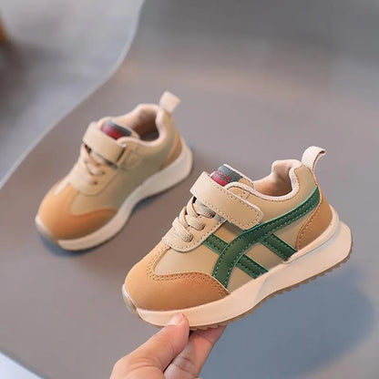 Children's white synthetic leather sneaker with Velcro strap on a non-slip rubber sole.