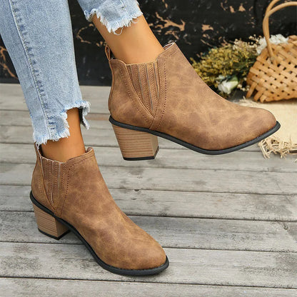 Black women's pointed toe ankle boots with a thick low square heel and slip-on design.