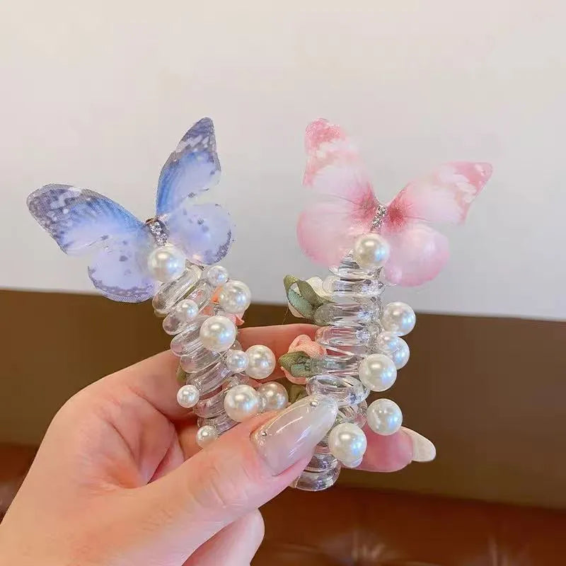 Colourful butterfly and pearl elastic hair band for children on a white background.