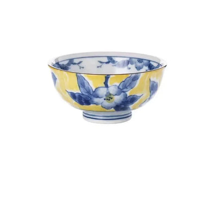 Yellow ceramic tableware set with colourful floral patterns, includes bowls and plates in Japanese style