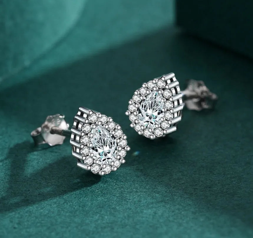 A pair of drop-shaped sterling silver ear studs with a diamond-cut finish.
