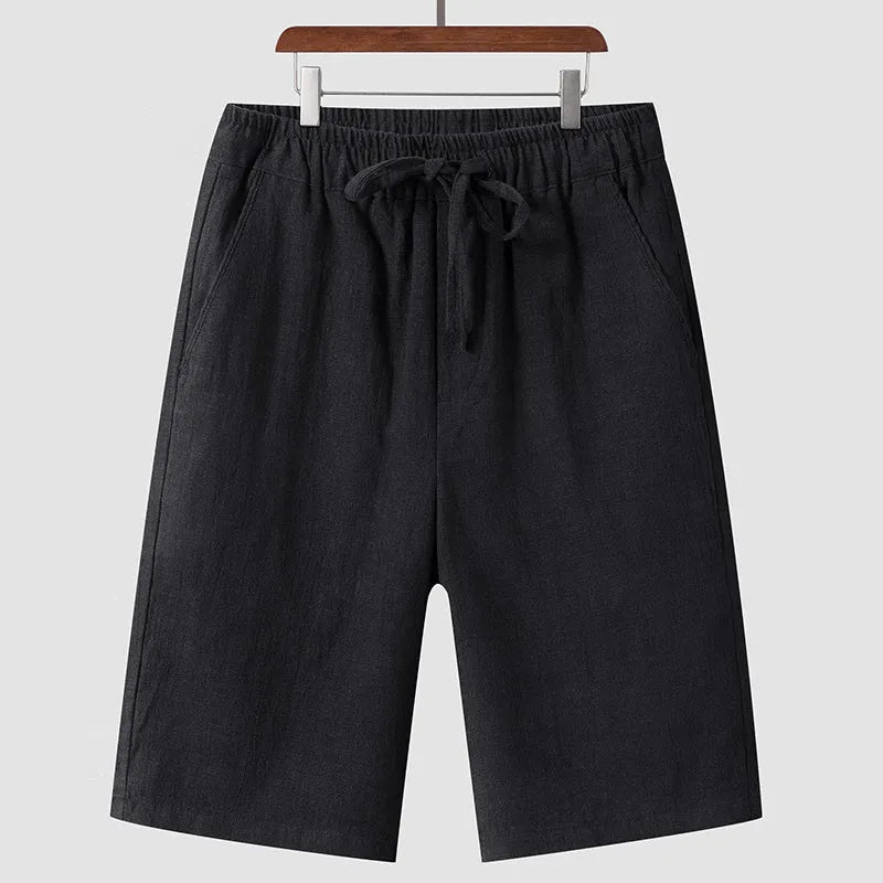 Men's beige linen casual shorts with a loose fit and elastic waistband on a neutral background.