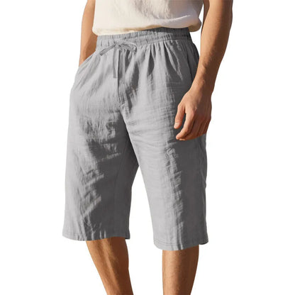 Men's loose-fit linen shorts in a solid colour with a drawstring waist and cropped leg length.