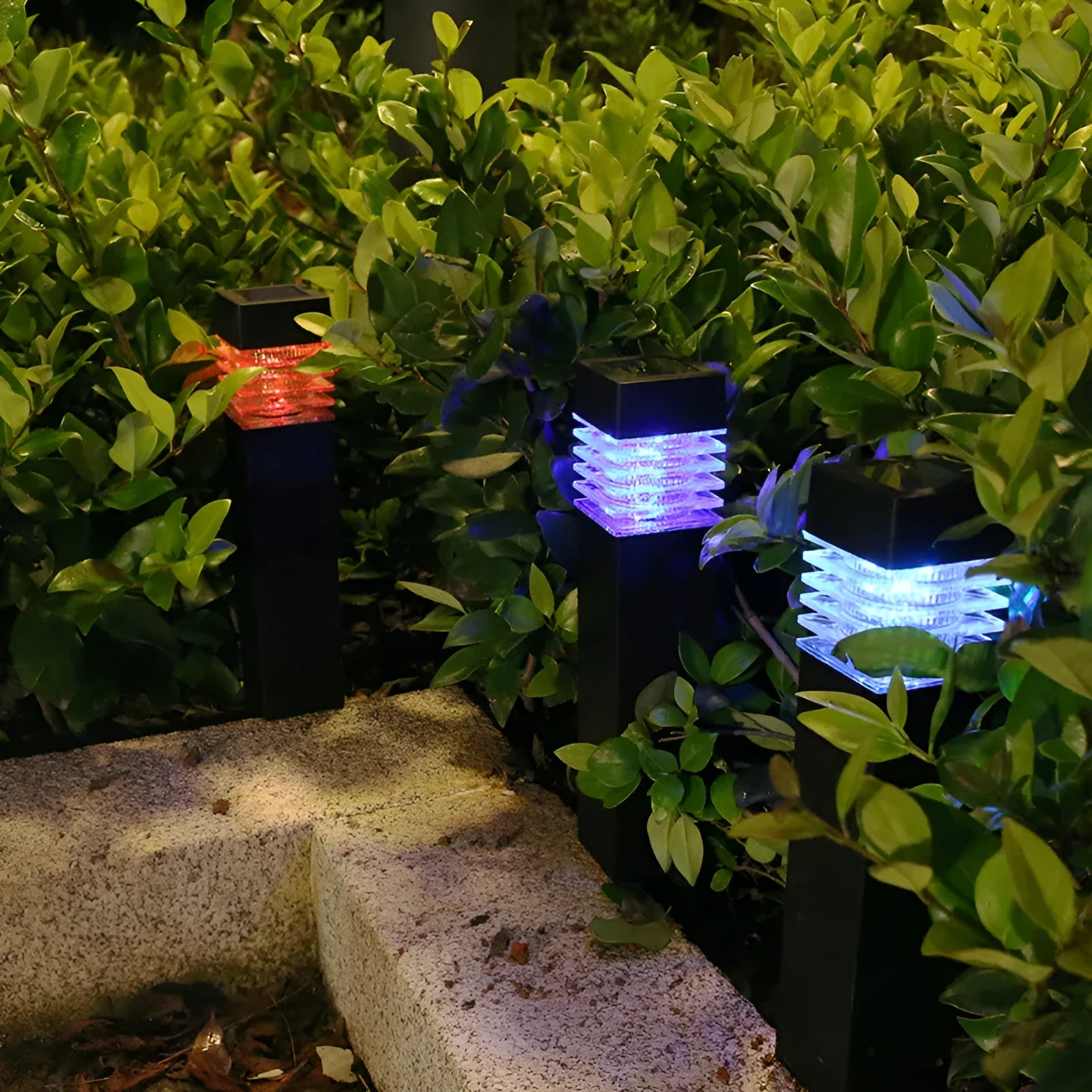 A tall, cuboid-shaped white solar lawn lamp standing in a garden.