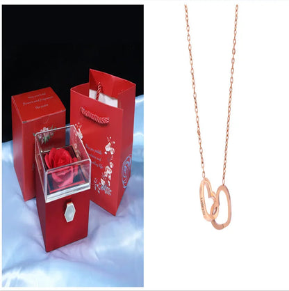 Rotating rose jewellery gift box with a preserved red rose under a clear acrylic dome, showing the interior rotating drawer.