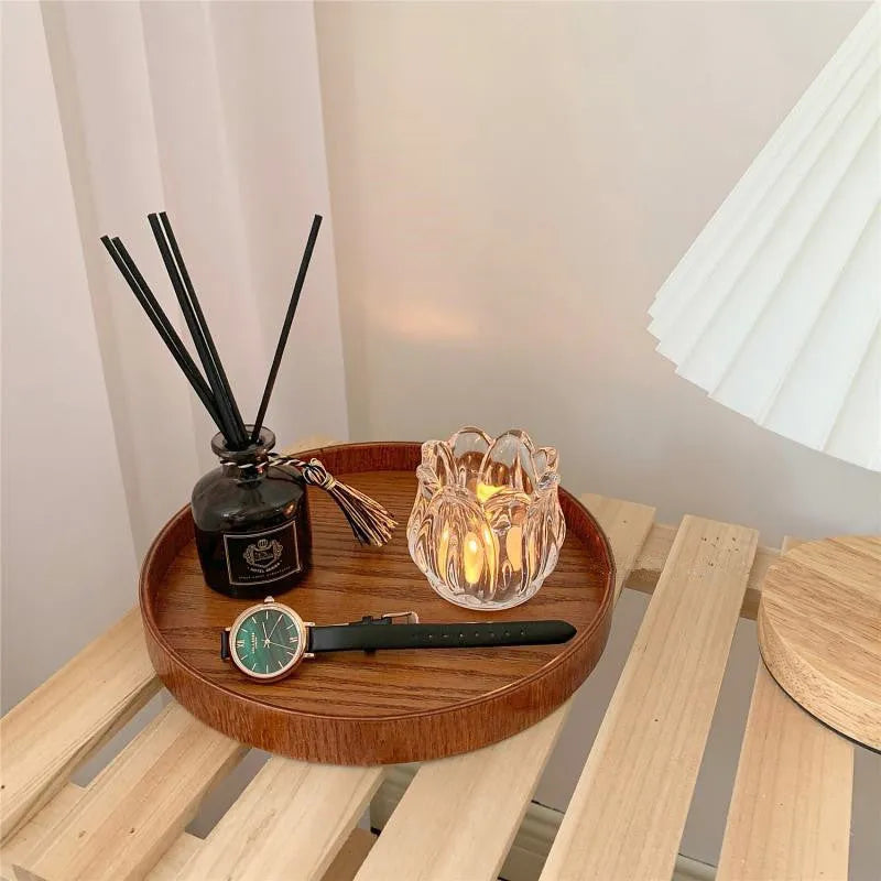 Transparent glass tulip candle holder with classic tumbler base on table