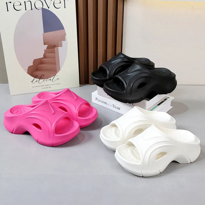 Women's white thick-soled EVA slippers with a round toe on a beach background.
