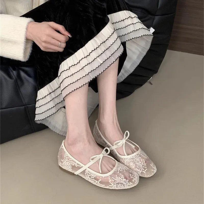 Pink Mary Jane evening shoes with flat lace, mesh upper, and a mid heel on a rubber sole.