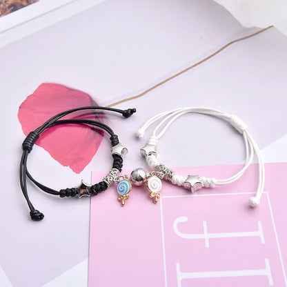 A pair of magnet couple bracelets with a suction clasp, showing various design options like clovers, crowns, and hearts.