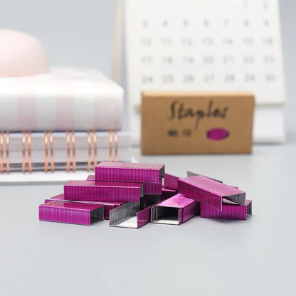 Box of 1000 metal stapling needles in rose gold, black, purple, and rose red colours.