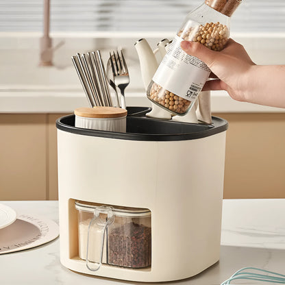 White rotating plastic kitchen storage bucket and a separate white spice box with four compartments on a countertop.
