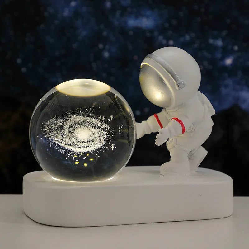 Glowing astronaut crystal ball night light with 6cm diameter and USB cable on wooden surface