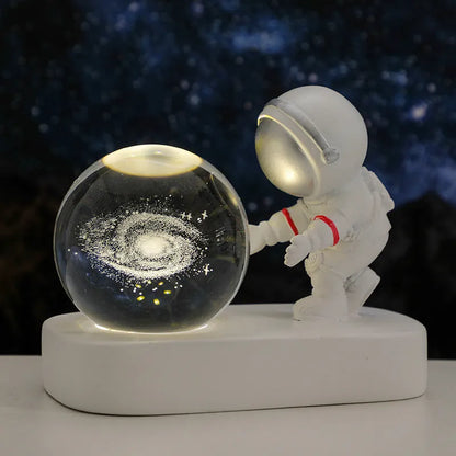 Glowing astronaut crystal ball night light with 6cm diameter and USB cable on wooden surface