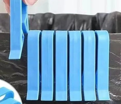 A white polypropylene plastic clip for holding a rubbish bag onto the rim of a bin.
