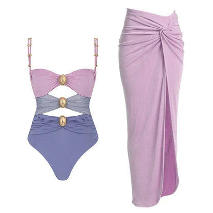 Women's solid colour one-piece swimsuit with gold buttons and a detachable skirt.