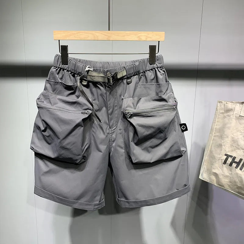 Men's black loose-fit work shorts with multiple pockets showing mid-waist design