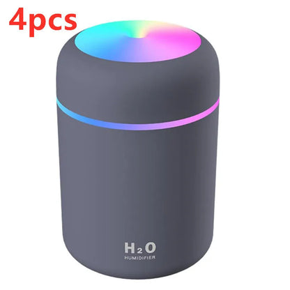 Pink USB desktop humidifier with LED lights and water tank on wooden desk
