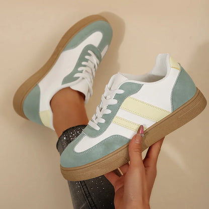 Women's green and white retro-style low-top casual pumps with cross straps and a flat rubber sole.