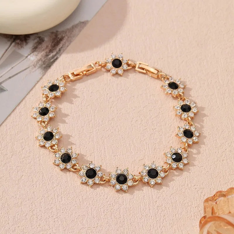 Gold and silver electroplated bracelets with flower charms set with coloured gemstones.