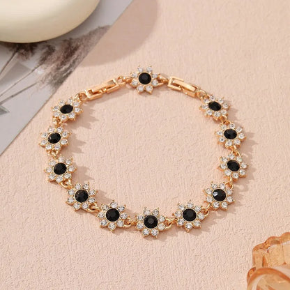Gold and silver electroplated bracelets with flower charms set with coloured gemstones.