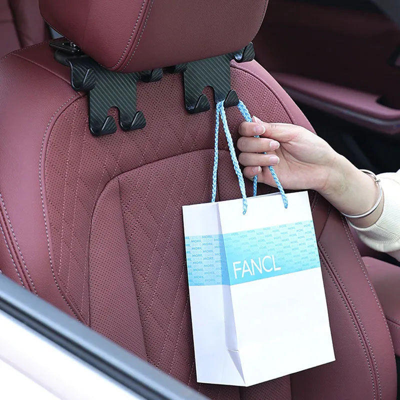 Black ABS plastic car hook and mobile phone holder bracket for rear seat mounting.