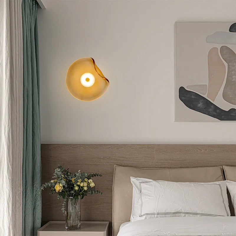 Round glass wall lamp mounted beside bed in cognac colour with 220V operation for bedside lighting