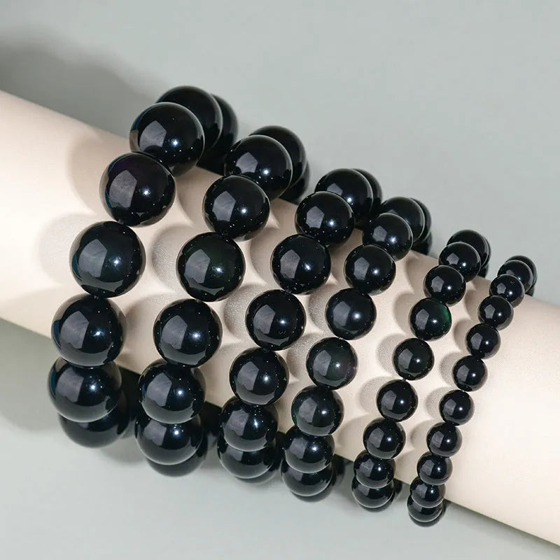 Hand-woven crystal bracelet made from genuine obsidian with ethnic style design for men and women available in multiple diameter sizes from 8mm to 16mm with six colour variations including black stone and rainbow eye obsidian for spiritual or fashion wear