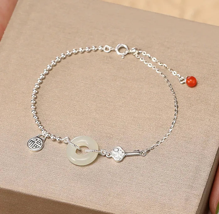 Silver women's bracelet with Hetian jade stones and a geometric peace buckle charm.