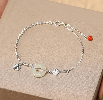 Silver women's bracelet with Hetian jade stones and a geometric peace buckle charm.