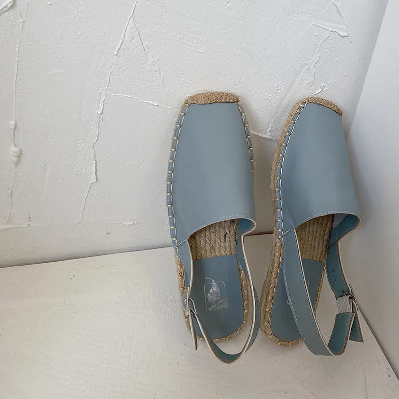 Women's flat canvas fisherman sandals in black, shown from the side on a white background.