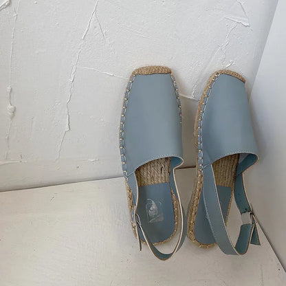 Women's flat canvas fisherman sandals in black, shown from the side on a white background.