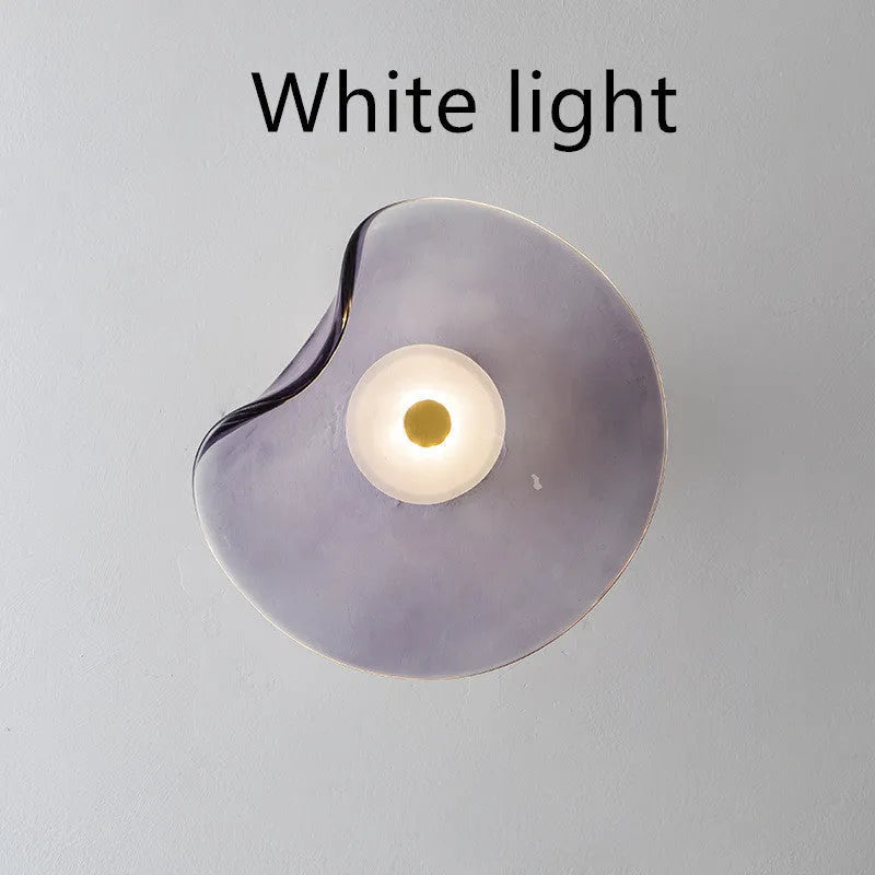 Round glass wall lamp mounted beside bed in cognac colour with 220V operation for bedside lighting