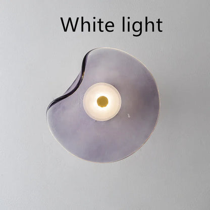 Round glass wall lamp mounted beside bed in cognac colour with 220V operation for bedside lighting